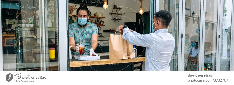 Mann holt Essensbestellung zum Mitnehmen ab abholend Lebensmittel Orden wegnehmen Lebensmittel-Lieferung Schutzmaske Gesichtsmaske Restaurant nur wegnehmen