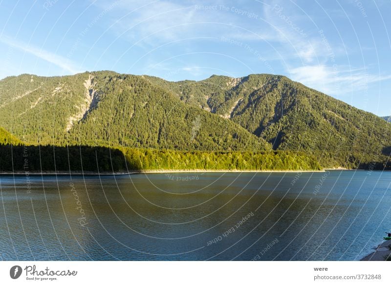 Blick über die Alpen und den Sylvenstein-Stausee an einem sonnigen Sommerabend Sonnenuntergang am See Hafengebiet Blauer Himmel Wolken Textfreiraum Abendsonne