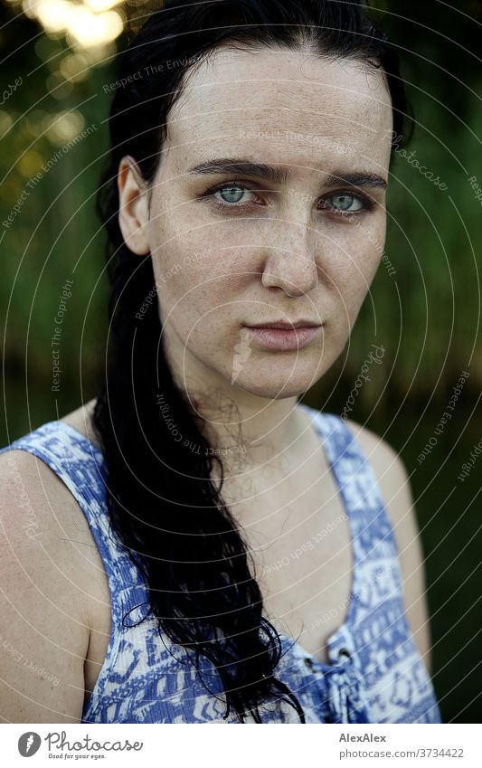 Nahes Portrait einer sommersprossigen Frau mit nassen Haaren in einem See vor Schilf schönes Wetter Stimmung selbstbewußt baden Kleid nasse haare weiblich