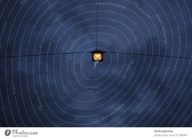 Licht einer Leuchte an einer Überspannungsanlage für Stadt, Straße, Platz und Verkehr am Abend leuchtende Lampe Straßenlampe himmel wolkken Farbiges Foto Himmel
