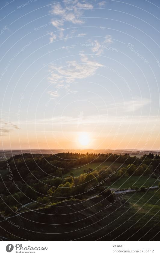 Sonnenuntergang über Wald Gegenlicht Himmel Weite Ruhe Idylle Wolken warm grün blau leuchten schön Naturschönheit draußen Schönes Wetter Licht Sonnenlicht