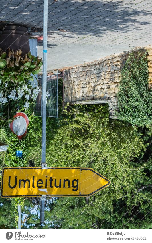 Die Welt steht Kopf, aber zum Glück gibt es eine Umleitung. Schild verdrehte Welt kopfüber Schilder & Markierungen Schriftzeichen Menschenleer Farbfoto