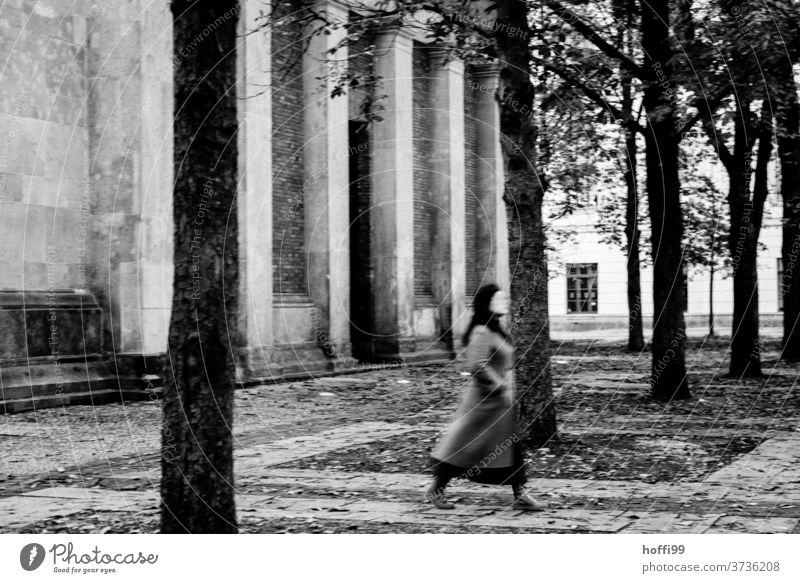 Eine Passantin quert eiligen Schrittes den herbstlichen Platz vor der neuen Wache in Berlin Neue Wache düster passieren Bewegung Bewegungsunschärfe Architektur