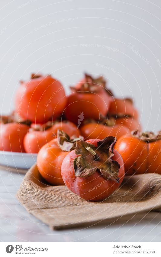 Reife Kakis auf dem Teller in der Küche Persimone Frucht süß Haufen frisch Vitamin Diät Ernährung Nährstoff lecker hell Tisch Gesundheit natürlich Lebensmittel