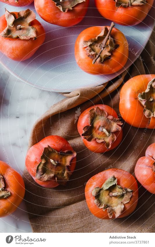 Reife Kakis auf dem Teller in der Küche Persimone Frucht süß Draufsicht Haufen frisch Vitamin Diät Ernährung Nährstoff lecker hell Tisch Gesundheit natürlich