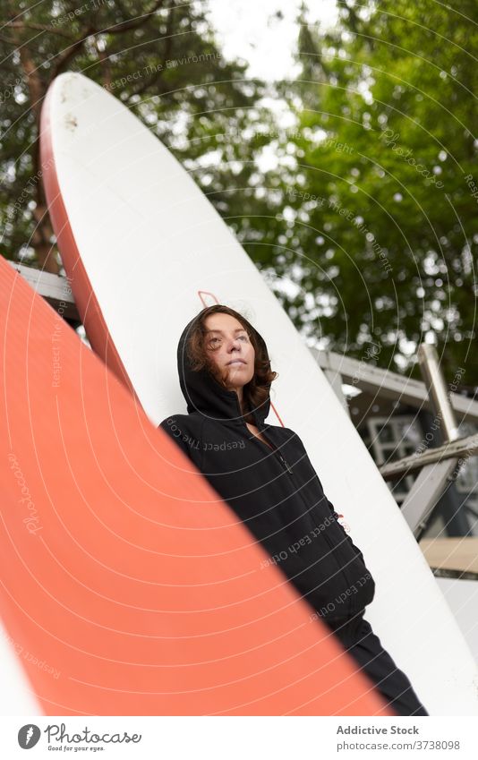 Sportlerin am Ufer mit Paddelbrett Frau sich[Akk] entspannen Surfer Windstille Surfbrett hölzern Stauanlage ruhen Holzplatte Surfen Sommer Athlet Aktivität