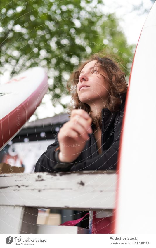 Sportlerin am Ufer mit Paddelbrett Frau sich[Akk] entspannen Surfer Windstille Surfbrett hölzern Stauanlage ruhen Holzplatte Surfen Sommer Athlet Aktivität