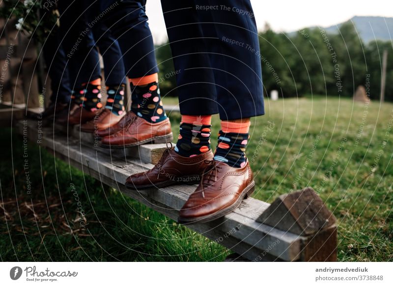 stilvolle Herrensocken. Stylischer Koffer, Herrenbeine, mehrfarbige Socken und neue Schuhe. Konzept von Stil, Mode, Schönheit und Urlaub Beine Kniestrümpfe