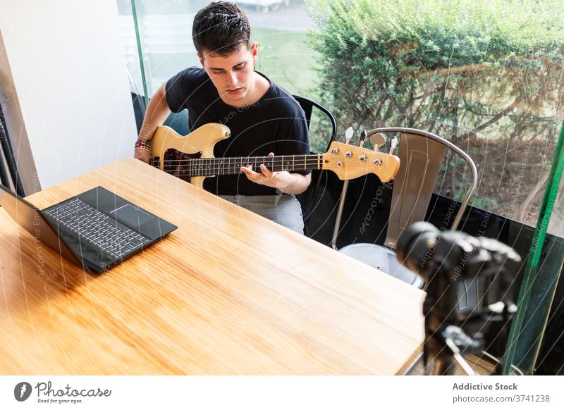 Junger Mann spielt Bassgitarre spielen Gitarre Musik stimmen Fähigkeit ausführen Musiker Instrument Klang Melodie Gesang Hobby jung männlich lernen Lifestyle