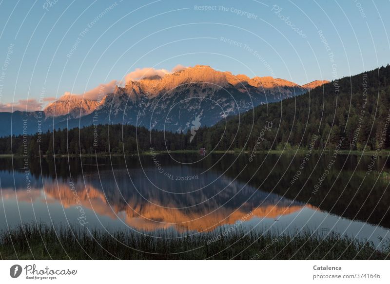 Still geht die Sonne auf, beleuchtet die Berggipfel die sich im Bergsee spiegeln Tannenwald Berge und Gebirge See Seeufer Himmel Wasser Landschaft Natur Umwelt