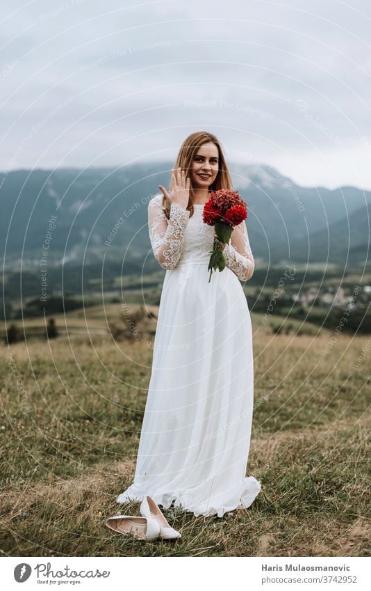 Schöne Braut im Brautkleid, den Ring an der Hand haltend, draussen in der Natur Erwachsener attraktiv Hintergrund schön Schönheit Blumenstrauß hochzeitlich