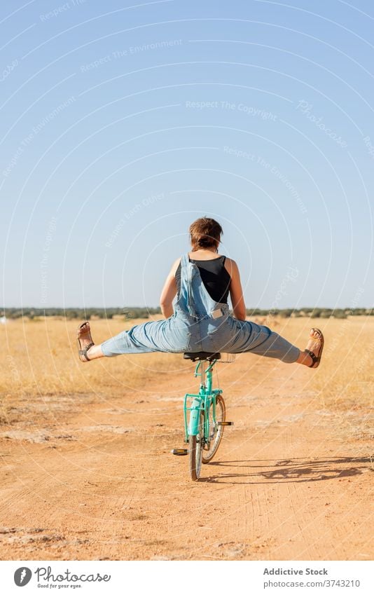 Frau auf Fahrrad in ländlicher Umgebung Straße Sand Sonnenlicht gesamt Landschaft Glück Gelassenheit Sonnenbrille Jeansstoff Sommer Natur sich[Akk] entspannen