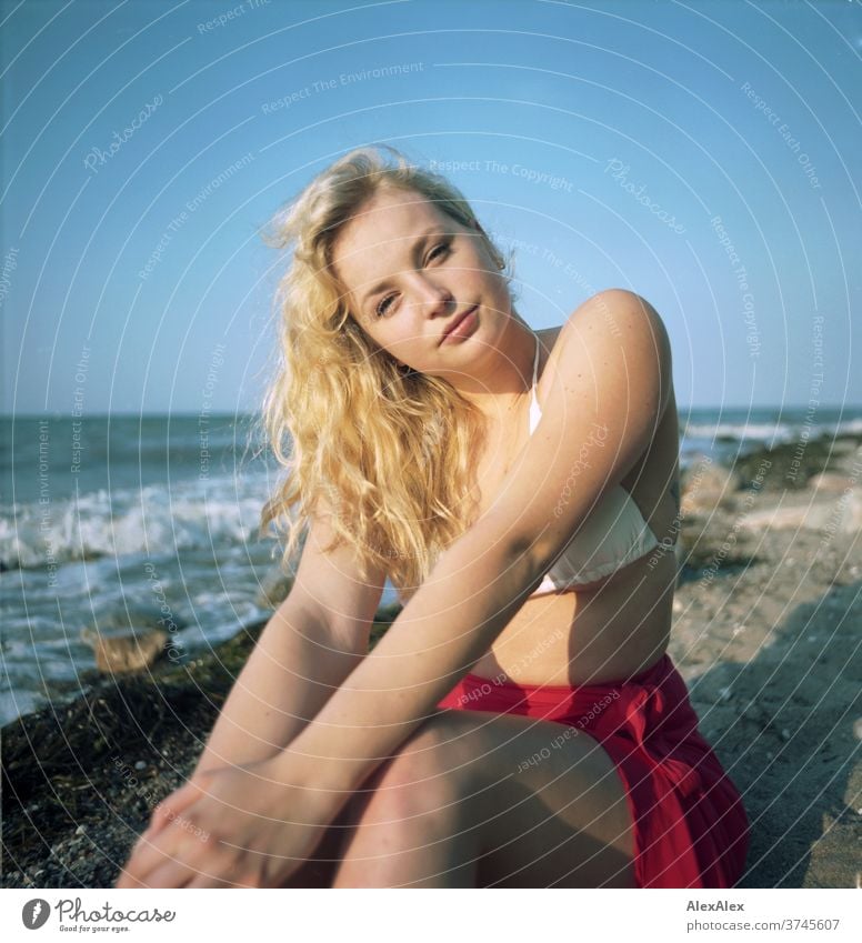 Analoges Portrait einer jungen Frau im Bikini am Ostseestrand Gischt Wellen Meer rot Strand heiß schönes Wetter Abendlicht Sonnenlicht selbstbewußt feminin