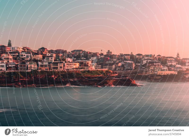 Ein rosaroter Sonnenaufgang im Frühling mit Blick auf Bronte und Tamarama in Sydney, Australien. bronte Bäder Meer Pool pools nsw newsouthwales Ostküste Strand