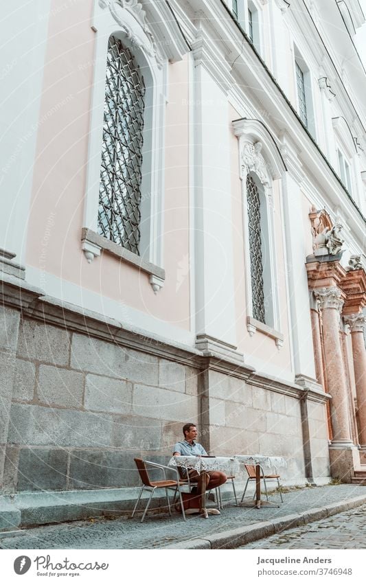 Mann sitzt in einem Straßencafe Café Kirche sitzen Erwachsene Außenaufnahme Tisch Kaffee Restaurant lässig Person trinken Straßencafé Getränk Tasse Lifestyle