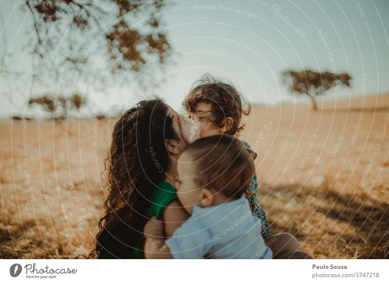 Mutter mit zwei Kindern auf dem Feld Mutterschaft Menschen Kindheit Pflege Familie & Verwandtschaft Liebe Eltern Fröhlichkeit Lifestyle Frau Halt Lächeln