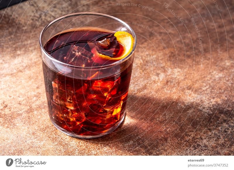 Boulevardier-Cocktail und Orangenschale alkoholisch Getränk boulevardier campari kalt trinken Eleganz frisch Frucht Glas Eis mischen orange rot rustikal