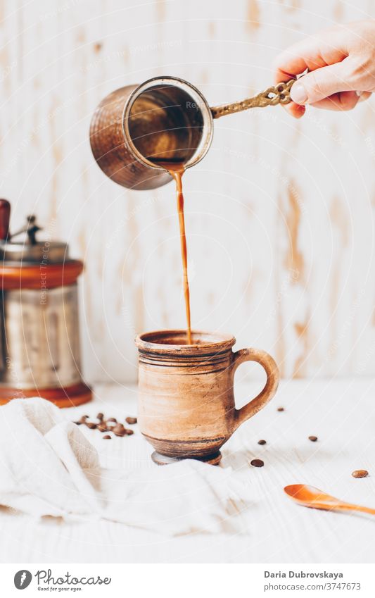 Kaffee in die Tasse giessen, Bohnen auf Holzuntergrund Aroma Frühstück hölzern Hintergrund Café Morgen trinken braun schwarz dunkel Getränk Koffein heiß frisch