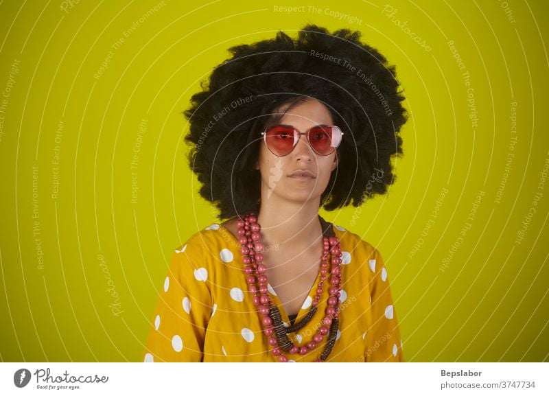 Bildnis eines indischen Mädchens mit lockigem Haar auf gelbem Hintergrund lustig Afro-Look Behaarung Frisur altehrwürdig Porträt retro farbenfroh Farben Rap