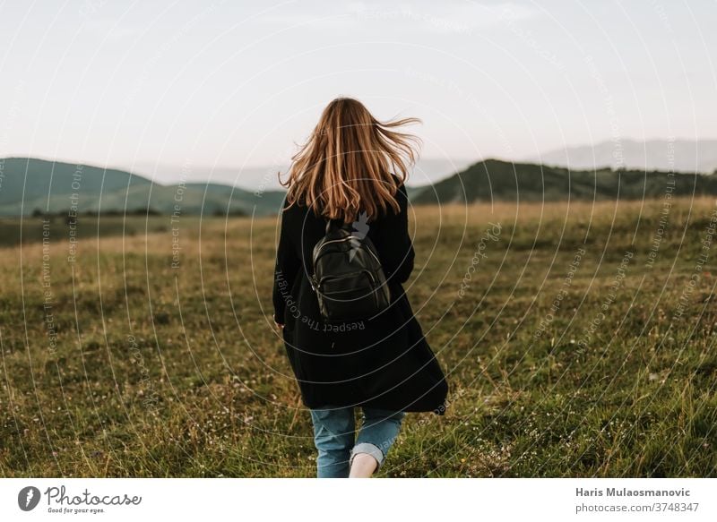 Frau mit Rucksack auf einem windigen Bergabenteuer Abenteuer weg von der Stadt Hintergrund schön Schönheit heiter Feld Freiheit Frischluft Spaß Gras Behaarung