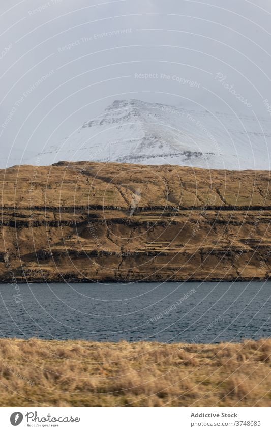 Felsenklippe in Meeresnähe auf den Färöer Inseln Klippe MEER Meereslandschaft Winter Schnee Saison kalt steil Gelände Färöer-Inseln felsig Landschaft