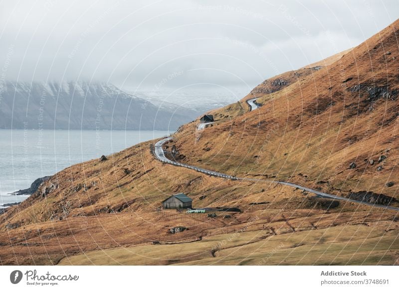 Landstraße und Haus am Meeresufer Straße Cottage Landschaft MEER Ufer Wolken Himmel Färöer-Inseln ländlich Natur malerisch Gebäude Hütte Bruchbude Küste reisen