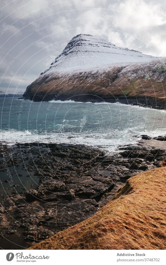 Felsenklippe in Meeresnähe auf den Färöer Inseln Klippe MEER Meereslandschaft Winter Schnee Saison kalt steil Gelände Färöer-Inseln felsig Landschaft