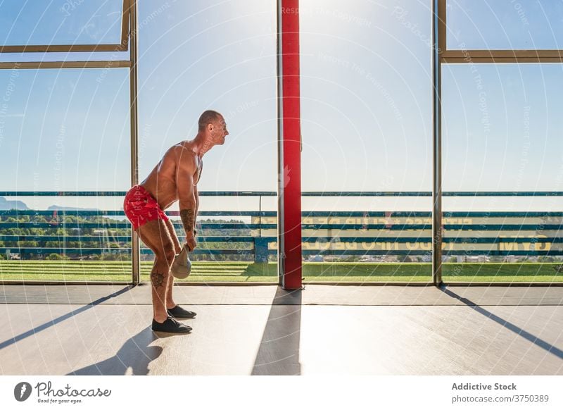 Athletischer Mann Training mit Kettlebell im Fitnessstudio Übung schwer Ausdauer stark Sportler muskulös männlich geräumig intensiv Körper passen Bestimmen Sie