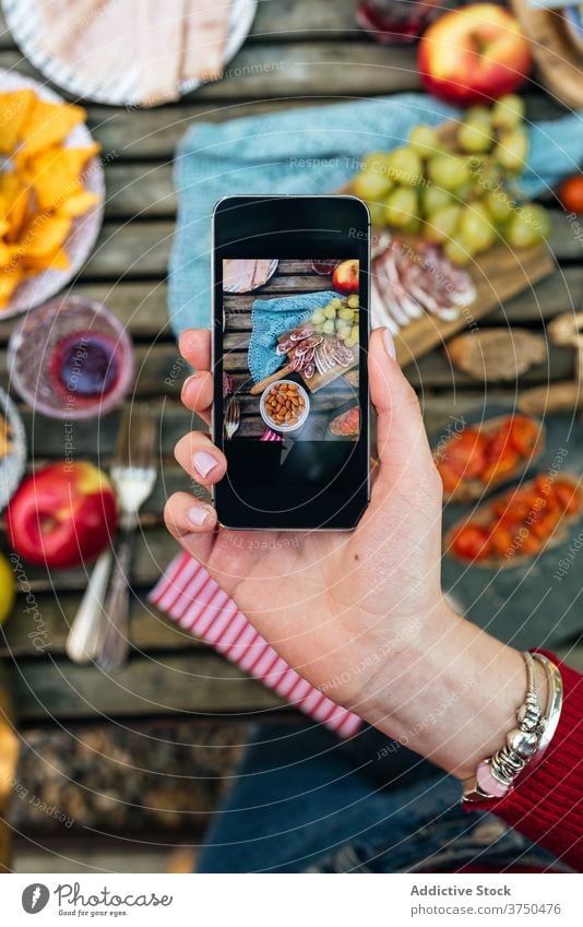 Crop Frau nimmt Foto von Tisch mit Essen Food-Fotografie Smartphone Lebensmittel Picknick Wald verschiedene benutzend valle del jerte Cacere Spanien lecker