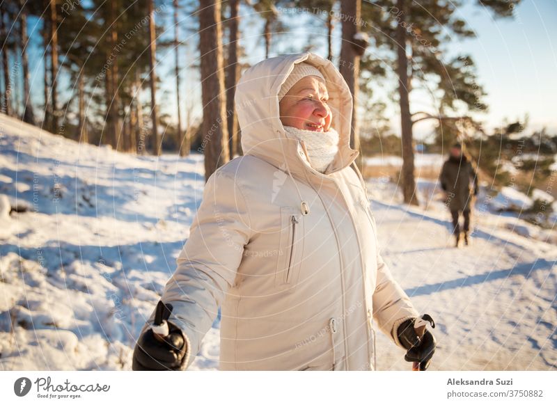 Wintersport in Finnland - Nordic Walking. Ältere Frau und Mann beim Wandern im kalten Wald. Aktive Menschen im Freien. Malerisch ruhige finnische Landschaft.