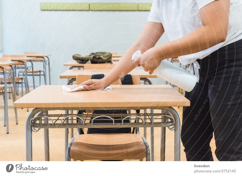 Lehrer desinfiziert Klassenzimmer-Schreibtisch Reinigen Spray Raumpfleger antibakteriell hygienisch Desinfektion Bildung Schule zurück zur Schule Klassenraum