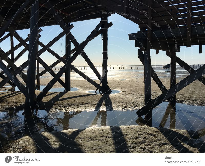 im Moment Ebbe | dynamisch Pfahlbau gegenlicht wasser sand strand holz architektur gebäude horizont skurril konstruktion schatten sonnig pfütze nass feucht