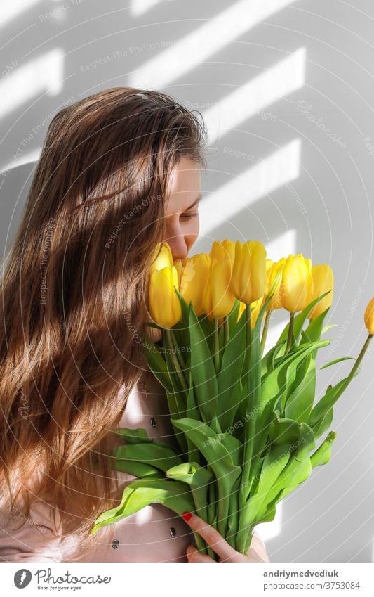 Frau mit Tulpen. Junge Frau mit gelben Blumen Tulpe natürlichen Porträt Lebensstil in der Nähe von weißem Hintergrund. März 8 jung Lifestyle Mädchen schön Natur