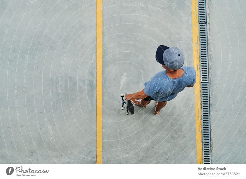 Mann mit Skateboard auf der Straße stehend Skater Großstadt urban Streetstyle trendy Asphalt Hobby männlich cool Sommer modern Freiheit Straßenbelag Kultur Stil