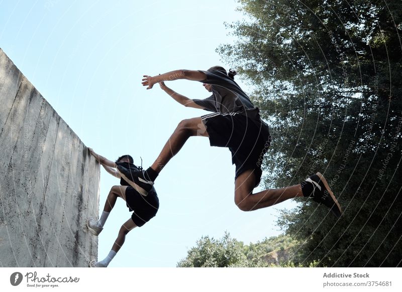 Männer springen in der Stadt über den Boden Le Parkour Stunt Trick Großstadt urban extrem Gefahr Hobby männlich Mut aktiv gutaussehend Aktivität professionell