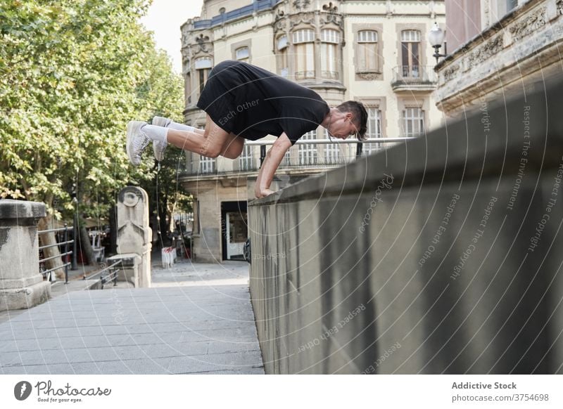 Starker Mann macht Parkour auf der Straße springen Le Parkour Hindernis Stunt Trick Gleichgewicht urban Adrenalin extrem männlich Großstadt Hobby Mut aktiv