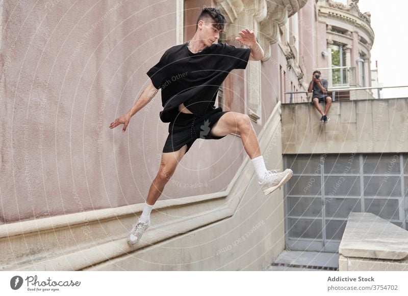 Starker Mann macht Parkour auf der Straße springen Le Parkour Hindernis Stunt Trick Gleichgewicht urban Adrenalin extrem männlich Großstadt Hobby Mut aktiv