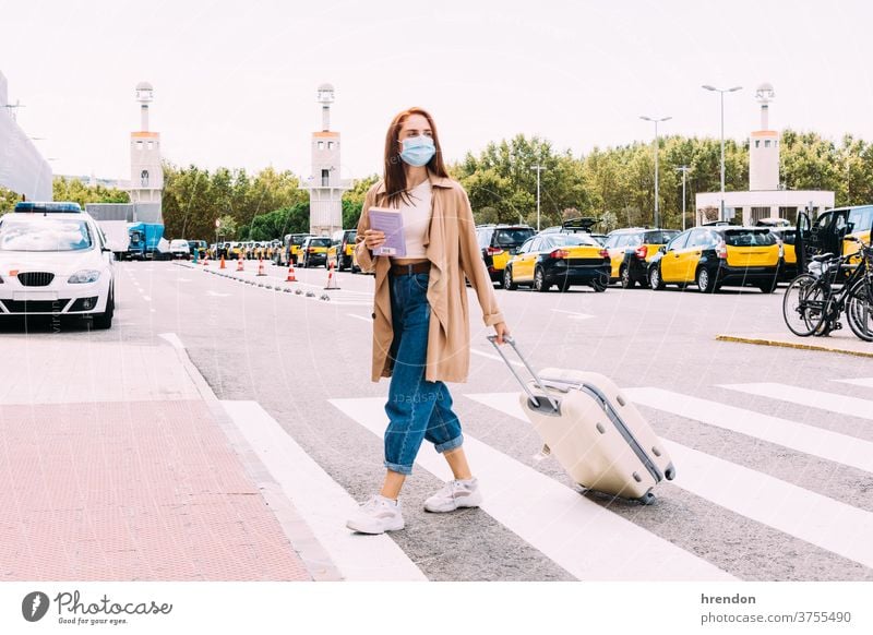 junge Frau mit Gesichtsmaske überquert die Straße, um ein Taxi aus dem Bahnhof zu nehmen Coronavirus Tourismus Transport Tourist Verkehr Öffentlich Reise