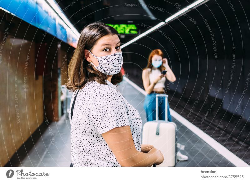 junge Frau mit Gesichtsmaske, die auf die U-Bahn wartet Transport Verkehr Öffentlich Reise Tourist Ausflug Pendler Arbeitsweg Zug reisend Wirtschaft Virus