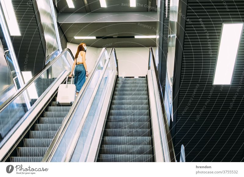 junger Tourist mit Gesichtsmaske benutzt U-Bahn-Rolltreppe Treppenhaus Terminal Coronavirus Tourismus Transport Verkehr Öffentlich Reise Ausflug Pendler