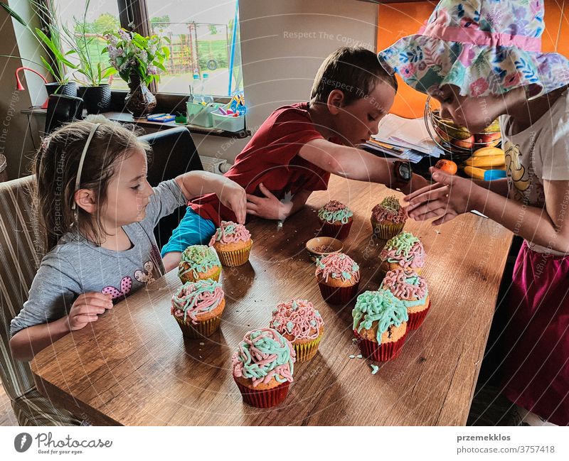 Kinder backen Muffins, bereiten Zutaten vor, dekorieren Kekse Cupcake dekorierend vorbereitend Essen zubereiten Familie heimisch Zusammensein Kindheit Glück