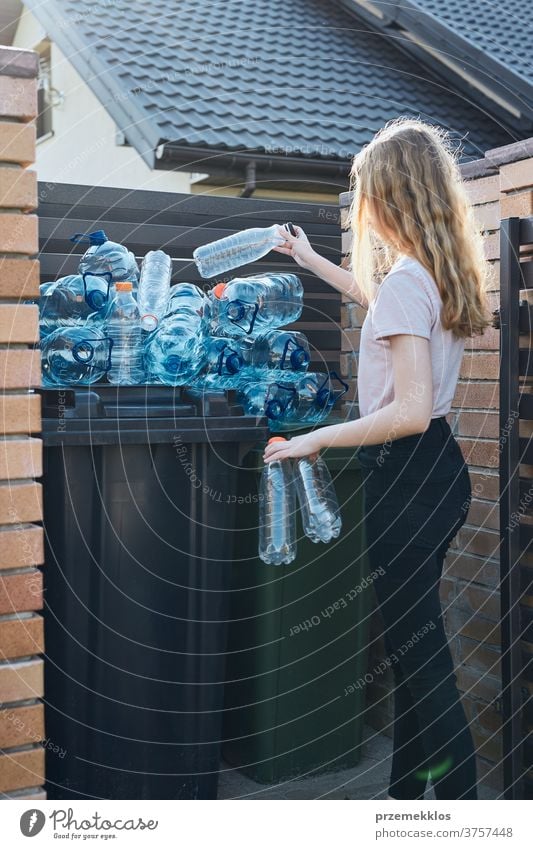 Junge Frau wirft leere gebrauchte Plastik-Wasserflaschen in den Mülleimer Behälter blau Flasche abholen sammelnd Container zerdrückt Entsorgung Ökologie Umwelt