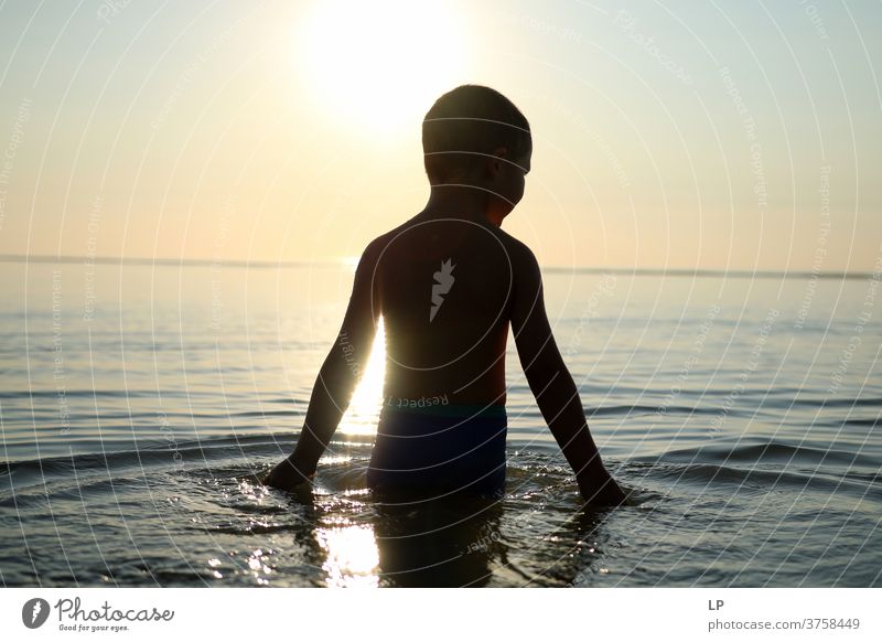 Kontrastieren der Silhouette eines Kindes mit Meer und Himmel Schwache Tiefenschärfe Schatten Licht Tag Außenaufnahme Aktion Körper Junge Mensch Versuch Mut