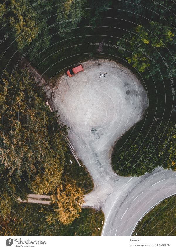 Auto und Mensch von oben Caddy Camping Wild Camping liegen Parkplatz Schneeengel Fläche Drohnenansicht Vogelperspektive Wald grün Baum Natur Abenteuer Strasse