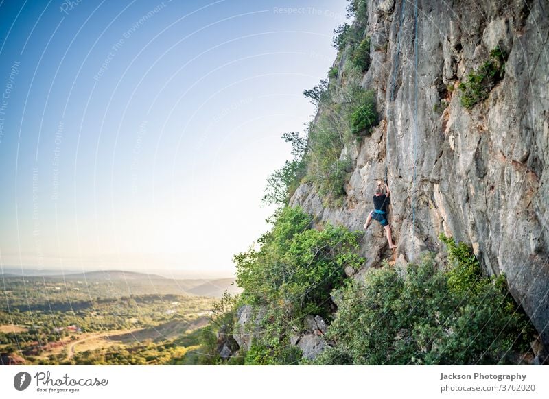 Mann klettert auf einen Felsen Klettern Portugal im Freien Park Natur hoch Aufsteiger aktiv Aktivität Adrenalin Abenteuer Algarve Mut Karabiner Herausforderung