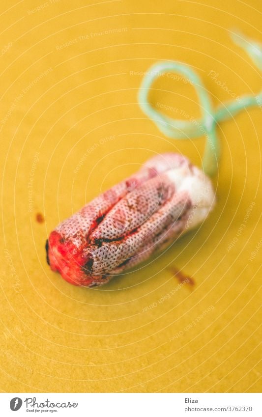 Blutiger Tampon auf gelbem Hintergrund. Menstruation. blutig echt Zyklus weiblich rot natürlich Realität nah menstruieren Periode OB blutgetränkt authentisch