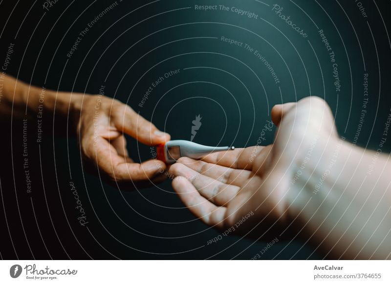 Ein alter Hase gibt einer jüngeren Hand ein Thermometer Grippe Schmerz Krankheit Hemd krank gutaussehend Schmerzen Virus müde Gesundheitswesen Menschen