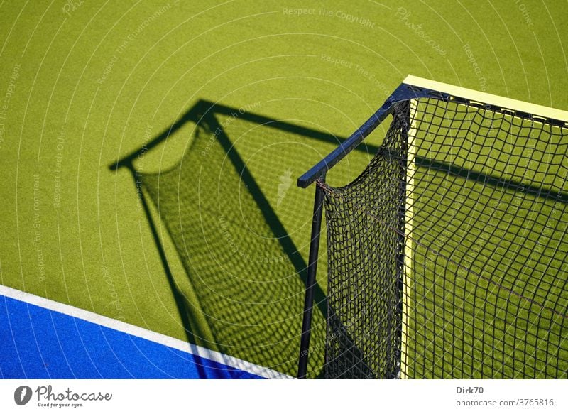 Hockeyplatz, menschenleer Sport Tor Hockeytor Licht Lichtspiel Schattenspiel selektiver fokus Netzwerk Tornetz Linie Grundlinie Spielen Freizeit & Hobby