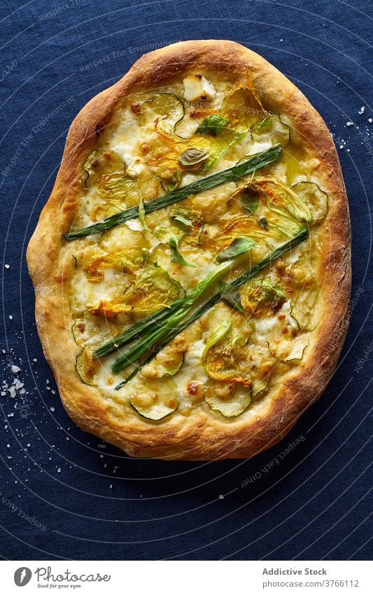 Draufsicht auf die vegetarische Pizza Zucchini Zwiebel Vegetarier blau Orangenwein Käse Kruste Salz Italienisch Küche Lebensmittel Mahlzeit Flachlegung Overhead