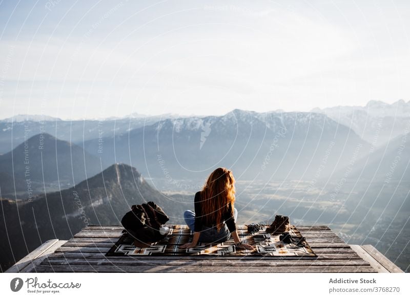 Reisende Frau auf Holzterrasse im Hochland Aussichtspunkt Berge u. Gebirge Morgen Reisender Nebel Sonnenstrahlen ruhig genießen Deutschland Österreich Tourist